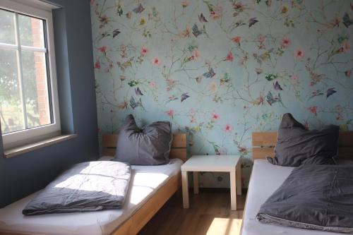 AltenhofLandperle Darze的一间卧室设有两张床和花卉壁纸
