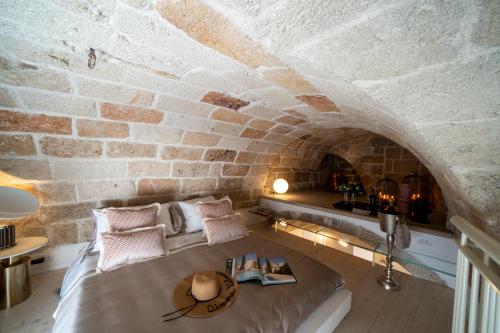 滨海波利尼亚诺Dimora Valmar Luxury Charm的一间设有床铺和砖墙的房间