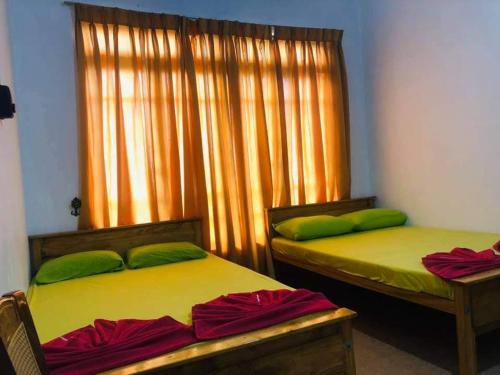 WattegamaNew Elkaduwa LOFT Hotel的两张带绿色枕头的床