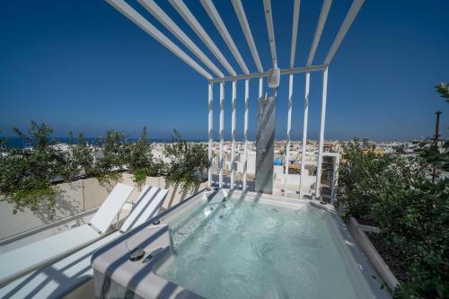 滨海波利尼亚诺Dimora Valmar Luxury Charm的海滩景阳台的热水浴池