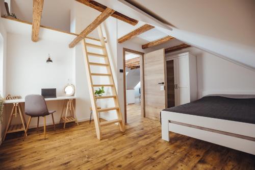 TrzinDrive Caffe Apartments的一间卧室设有梯子、一张床和一张书桌