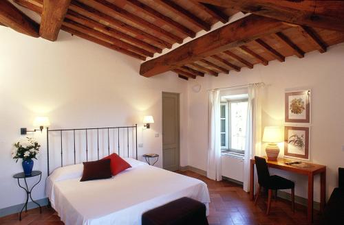 圣吉米纳诺杜慈别墅酒店的一间卧室配有一张床、一张书桌和一个窗户。