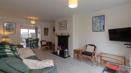 巴利卡斯尔Strand Cottages Ballycastle Seafront的带沙发和壁炉的客厅