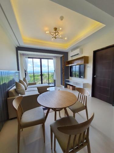 大雅台A condo with lake view near Highlands Steakhouse的客厅配有桌椅和沙发