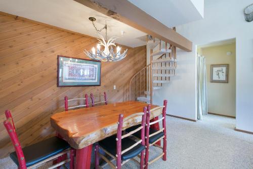马姆莫斯湖阿斯彭溪101号格莱特艾斯凯普斯酒店的一间带木桌和楼梯的用餐室