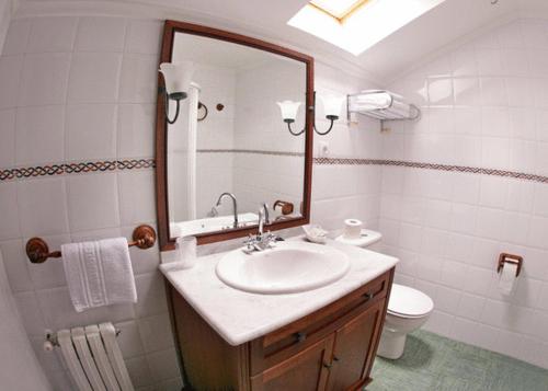 Puentenansa波萨达菲德尔旅馆的一间带水槽、卫生间和镜子的浴室
