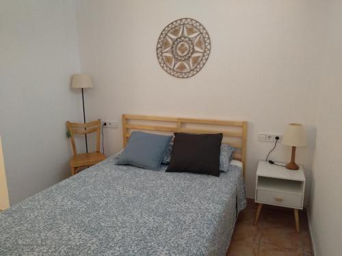 桑特费柳德吉克索尔斯Pis a Sant Feliu de Guíxols的卧室配有一张床,墙上挂着一个钟