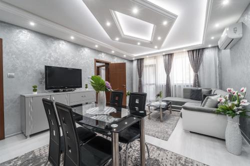 阿塞诺夫格勒City Apartments - a brand new luxury & comfy.的客厅配有餐桌和电视