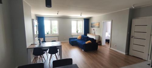 厄尔科Apartamenty Przystań的客厅配有蓝色的沙发和桌子