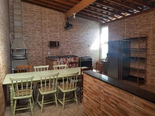 洛韦拉Casa 1km Anhanguera e Churrasqueira Wi-Fi的厨房配有带椅子的大柜台和冰箱