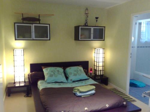 马尼库尔勒翁格尔灰姑娘别墅的一间卧室配有一张带两盏灯的床,墙上有两张照片
