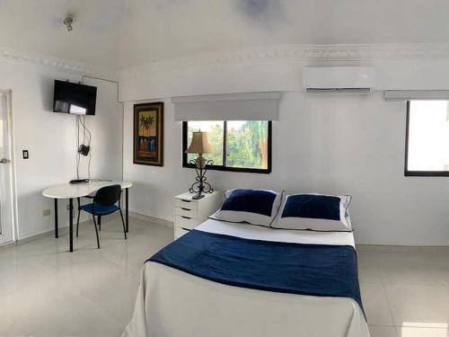 圣多明各Room in Condo - Malecon Premium Rooms的白色卧室配有床和桌子