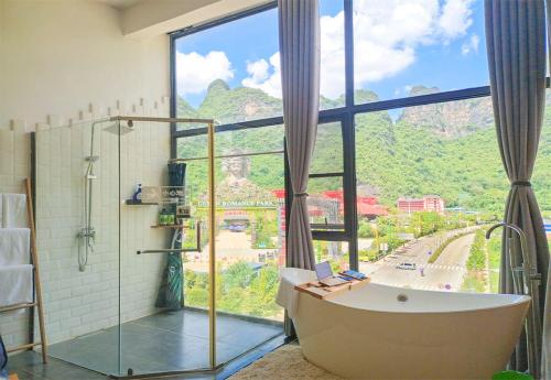 阳朔Sure I Do全景山宿的带浴缸的浴室和大窗户