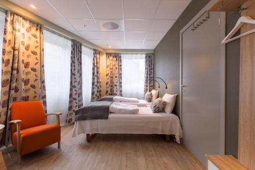 布伦讷于松Corner Hotell的一间卧室配有一张床和一张橙色椅子