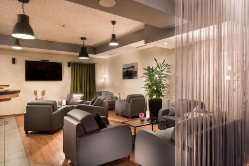 多特蒙德多特蒙德机场贝斯特韦斯特酒店的带沙发和椅子以及电视的等候室