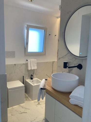 阿纳卡普里“CapriOleum” esclusive place的白色的浴室设有水槽和镜子