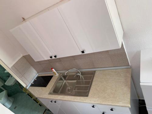 维利波吉Willy Apartments的厨房配有水槽和白色橱柜