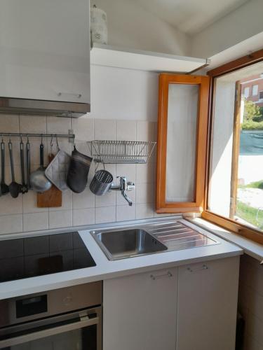 锡罗洛Appartamento a Sirolo centro的厨房设有水槽和窗户。