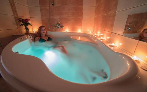 耶塞尼克Hotel Slovan的浴缸里的妇女,有灯
