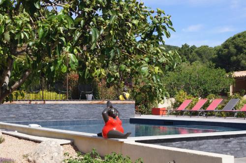 维琪奥港Les Jardins De Santa Giulia - Charmante chambre d'hôte 1的坐在游泳池旁长凳上的女人