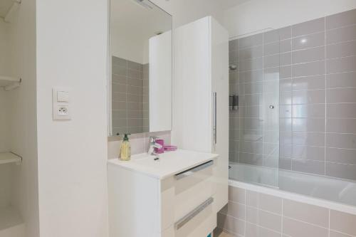 克莱蒙费朗La Halte de Saint-Pierre的白色的浴室设有水槽和淋浴。