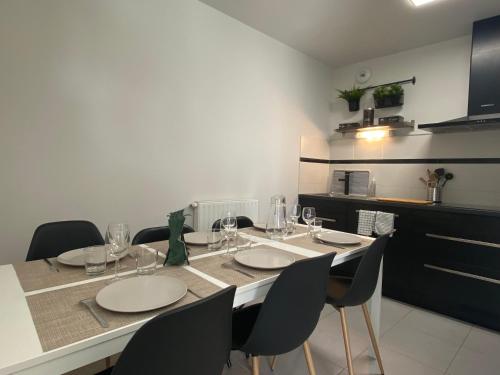 布吕兹Appartement familial tout confort - 3 chambres, grande terrasse privative - Vert Buisson - Bruz的餐桌、椅子和酒杯