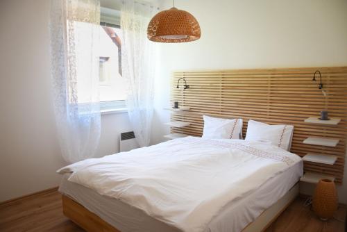 多纳瓦利Štýlový apartmán v srdci Donovalov的卧室设有一张白色大床和一扇窗户。