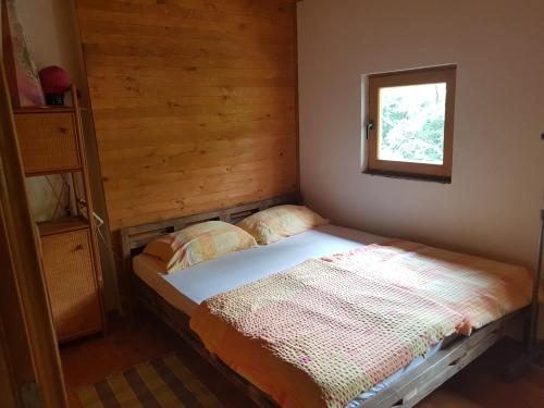 科尼茨Potok kuca sa bazenom的窗户客房内的小床