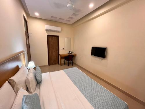 诺伊达Hotel Mithila Residency Noida - Couple Friendly Local IDs Accepted的一间酒店客房,配有一张床和一台电视