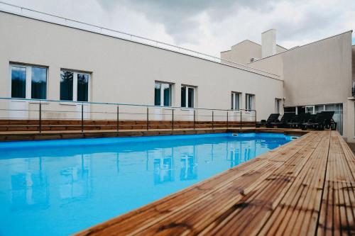 派尔努维斯洛斯酒店的一座大楼前的带木桌的游泳池