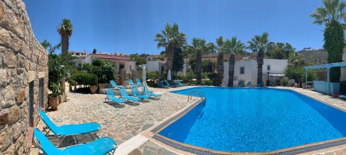 斯科拉Patmos Garden的一个带蓝色躺椅的游泳池,棕榈树