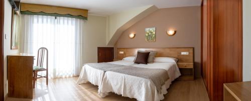 桑亨霍维加纳瓦酒店的一间卧室设有一张大床和一个窗户。