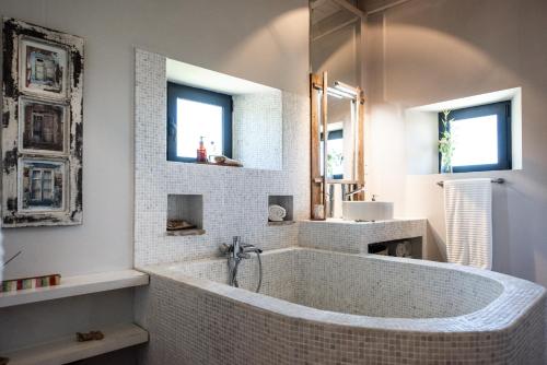 塔维拉Altanure - Casa Terra Ecological Boutique Hotel的带浴缸的白色浴室和2扇窗户。
