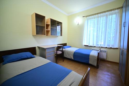 TsovazardSevan Tarsus Guesthouse的酒店客房配有两张床和一张书桌