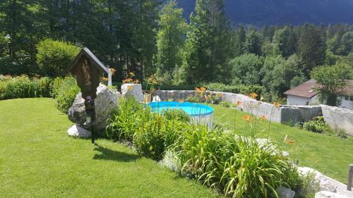 格赖瑙Alpenchalet Zum Jeremia的庭院内带游泳池的花园