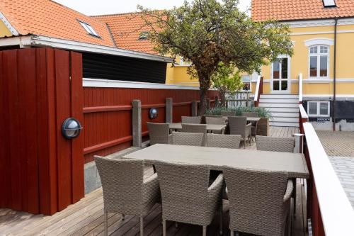 斯卡恩Ankerhus Skagen的一个带桌椅和围栏的庭院