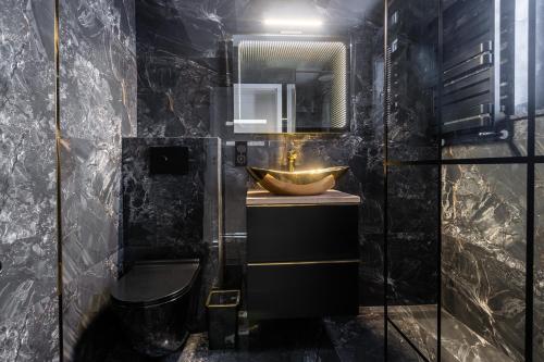 库瑞尼卡慕斯卡PORT 77的一间带水槽、卫生间和镜子的浴室
