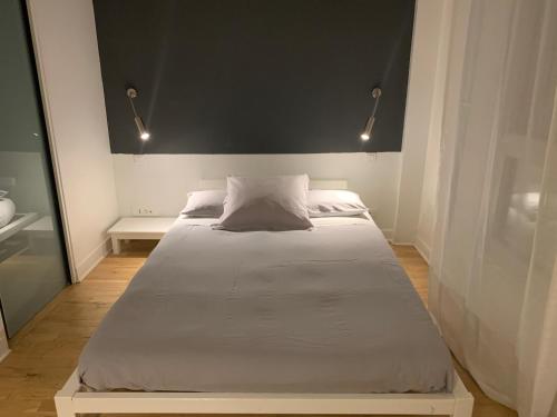 塞纳河畔讷伊Trés Beau Studio (face bois), 10mn de l'Etoile的一间卧室配有一张大床和黑色床头板