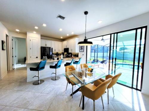 珊瑚角Blue Door Retreat - Luxury Pool Home - sleeps 8的厨房以及带玻璃桌和椅子的用餐室