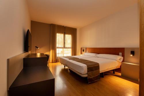 阿尔么丽亚Vértice Indalo Almería的酒店客房设有床和窗户。