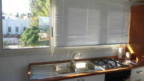 莱乌卡Attico Panoramico的厨房设有水槽和窗户。