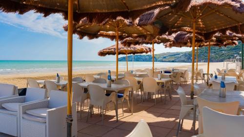 佩斯基奇Centro Turistico San Nicola的海滩上的一组桌椅