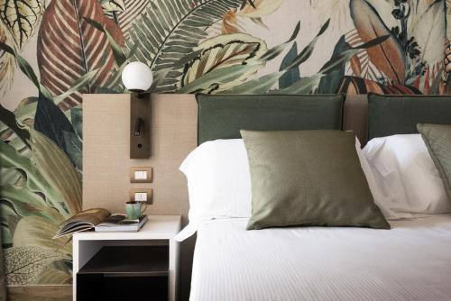 比比翁Life Hotel的一间卧室配有一张带植物壁纸的床