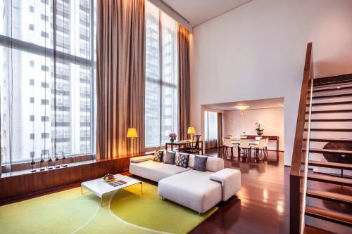 曼谷COMO曼谷大都会酒店的客厅配有白色沙发和大窗户