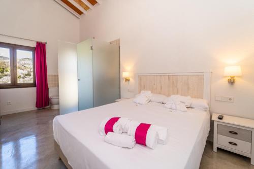 RelleuHostal Foies de Baix的卧室配有白色大床和红色及白色毛巾