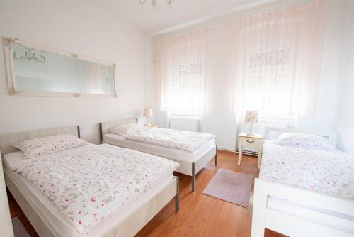 波热加GoodLife Holiday House - Family & Friends的配有2张床的白色墙壁和窗户客房