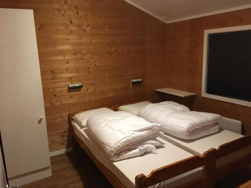 哈山Hafjell/Lillehammer Sorlia 3 bedroom Cabin的木墙客房的两张床
