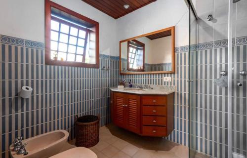 坎波斯杜若尔当Suítes Villa Panorama的带浴缸、水槽和镜子的浴室