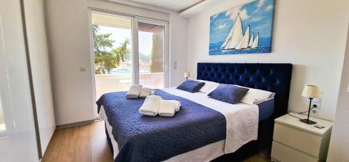杜布罗夫尼克Aquamarine Deluxe Apartment的一间卧室配有蓝色的床和毛巾