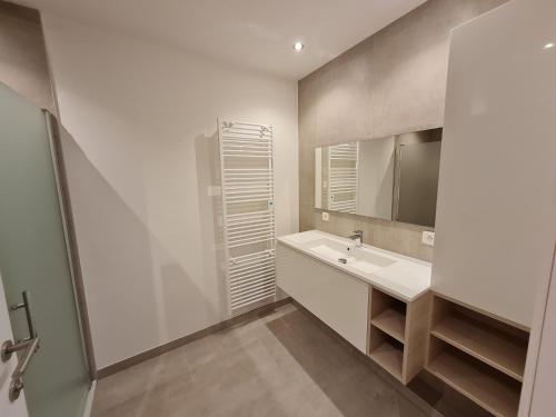 奥斯坦德Vakantiehuis Mariakerke的白色的浴室设有水槽和镜子